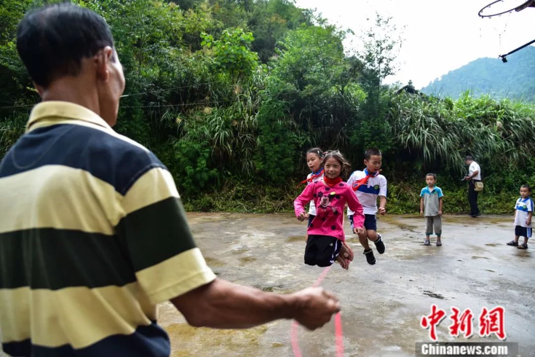 「中新社」杀了自家过年的大猪建教学楼，他用一根扁担撑起一座学