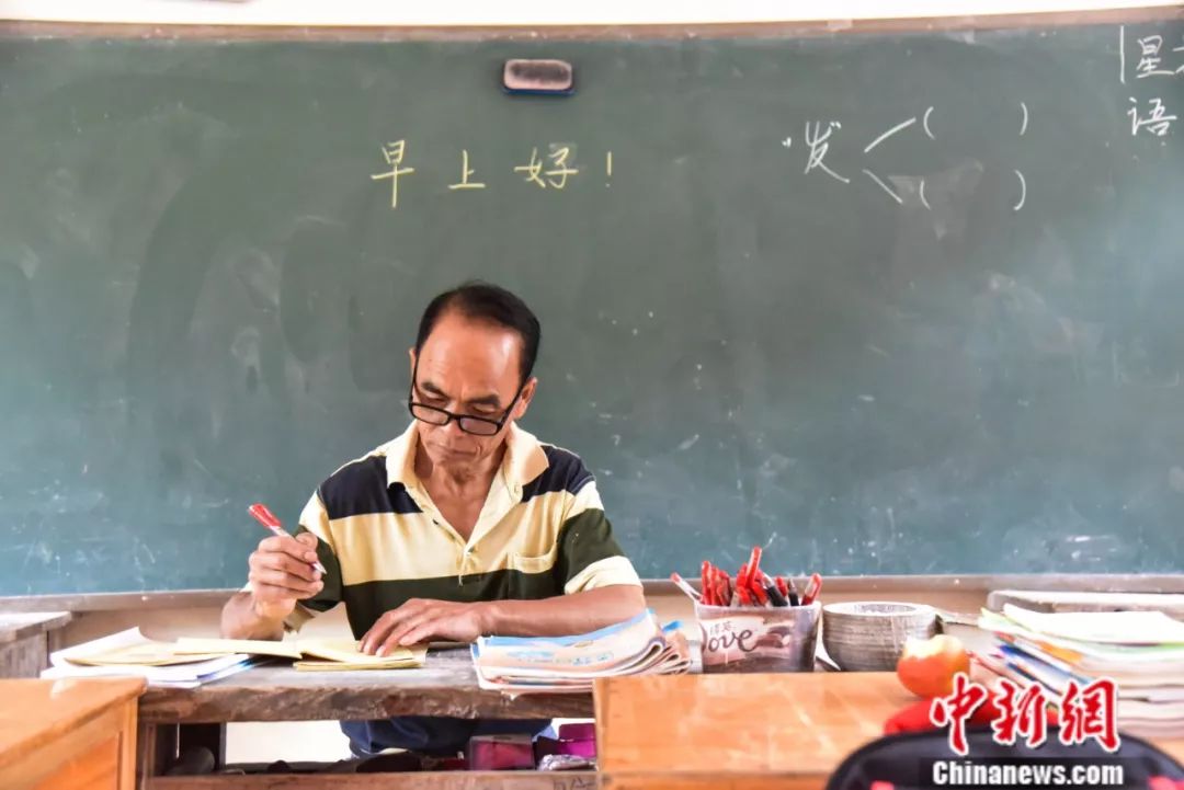 「中新社」杀了自家过年的大猪建教学楼，他用一根扁担撑起一座学