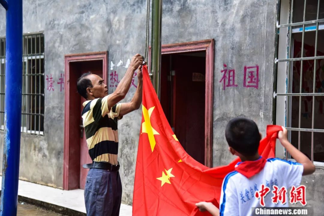 「中新社」杀了自家过年的大猪建教学楼，他用一根扁担撑起一座学