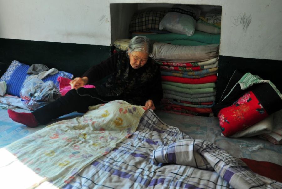 花甲老太太缝被子褥子面等着儿女回家.
