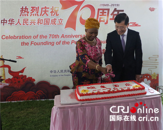 图片默认标题_fororder_3.郭少春和穆欣古丽在中国驻津巴布韦使馆举办的国庆７０周年招待会上同切蛋糕。