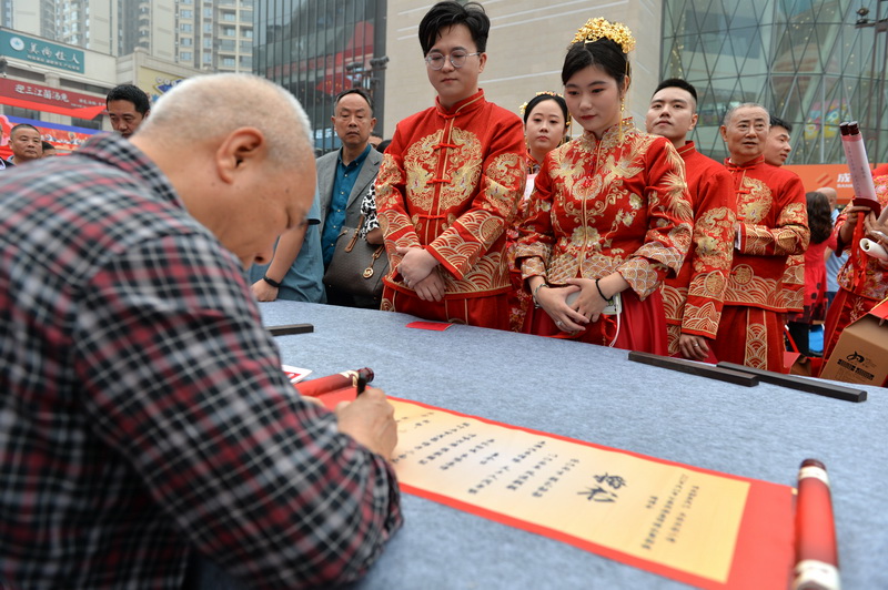 内江:太甜了 68对“新人”举行集体婚礼_fororder_书法家为“新人”们书写集体婚礼“婚书” (1).JPG