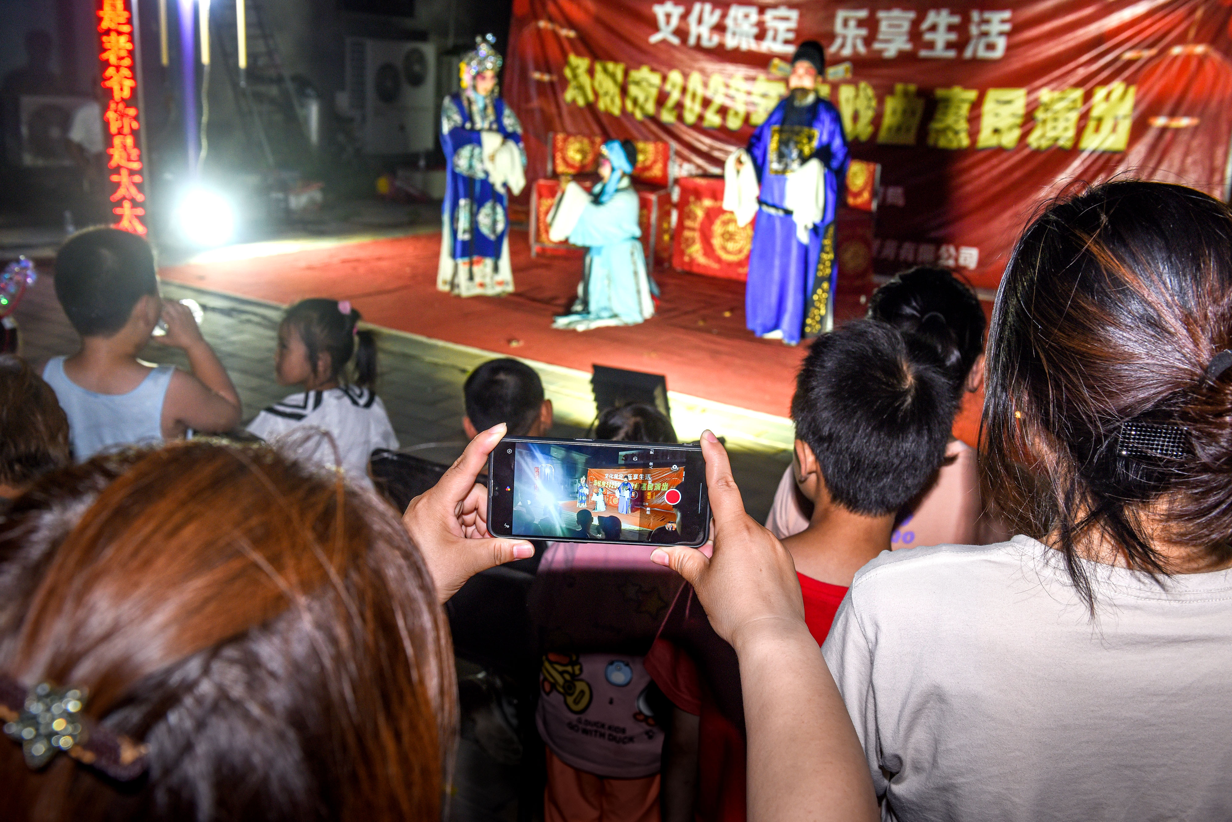 图片默认标题_fororder_6月18日晚,在河北省涿州市“戏曲进乡村”剧团走进码头镇东杨合庄村开展文化惠活动。图为村民用手机记录精彩的戏曲演出。刘永兴 摄