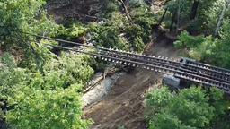美国佛蒙特州洪水成灾：桥梁被冲垮 只留铁轨悬在半空