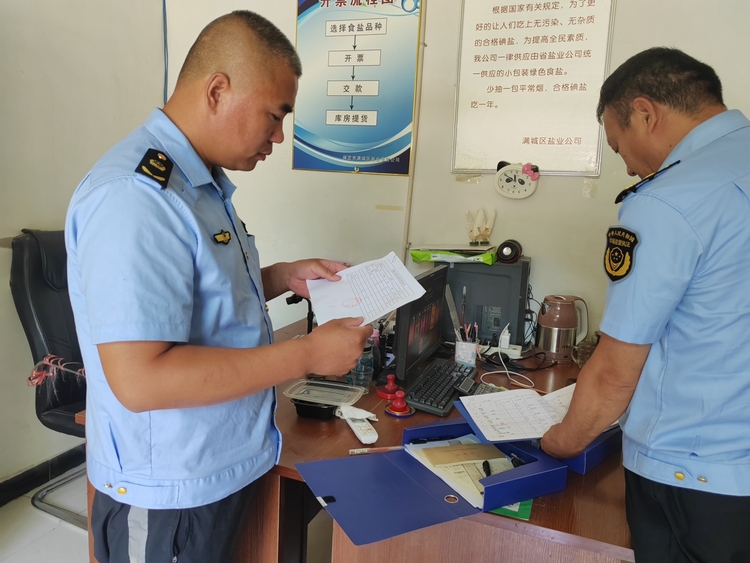 图片默认标题_fororder_满城区市场监管人员查看食盐销售台账 摄影 贾林静