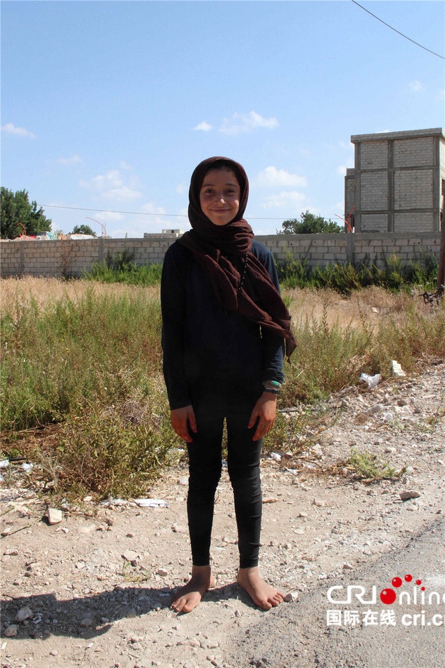 黎巴嫩南部某难民聚居点的一名叙利亚女孩,光着脚,对相机特别感兴趣