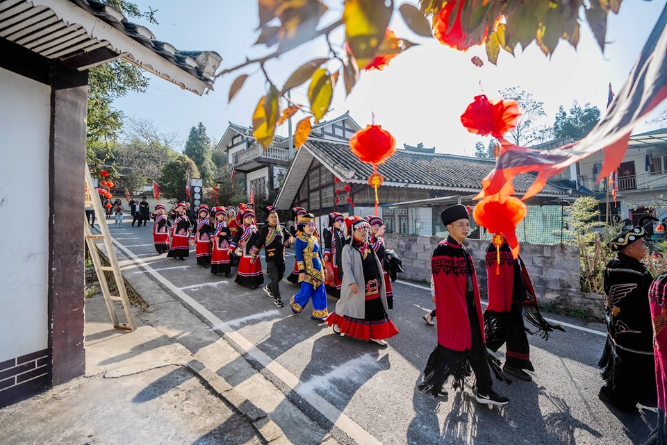贵州毕节:乡邻一家亲 共庆彝族年_fororder_2023年11月19日,在贵州省毕节市百里杜鹃管理区普底乡迎丰村,前来参加彝族年的群众排队进村。 (2)