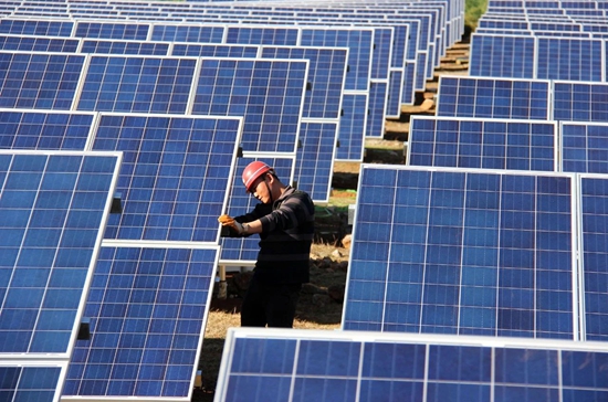 贵州威宁：从0到170亿元 “追风逐日”新能源_fororder_贵州首个光伏电站——威宁平箐太阳能光伏电站，施工人员在维护太阳能电池板。（何欢 摄）