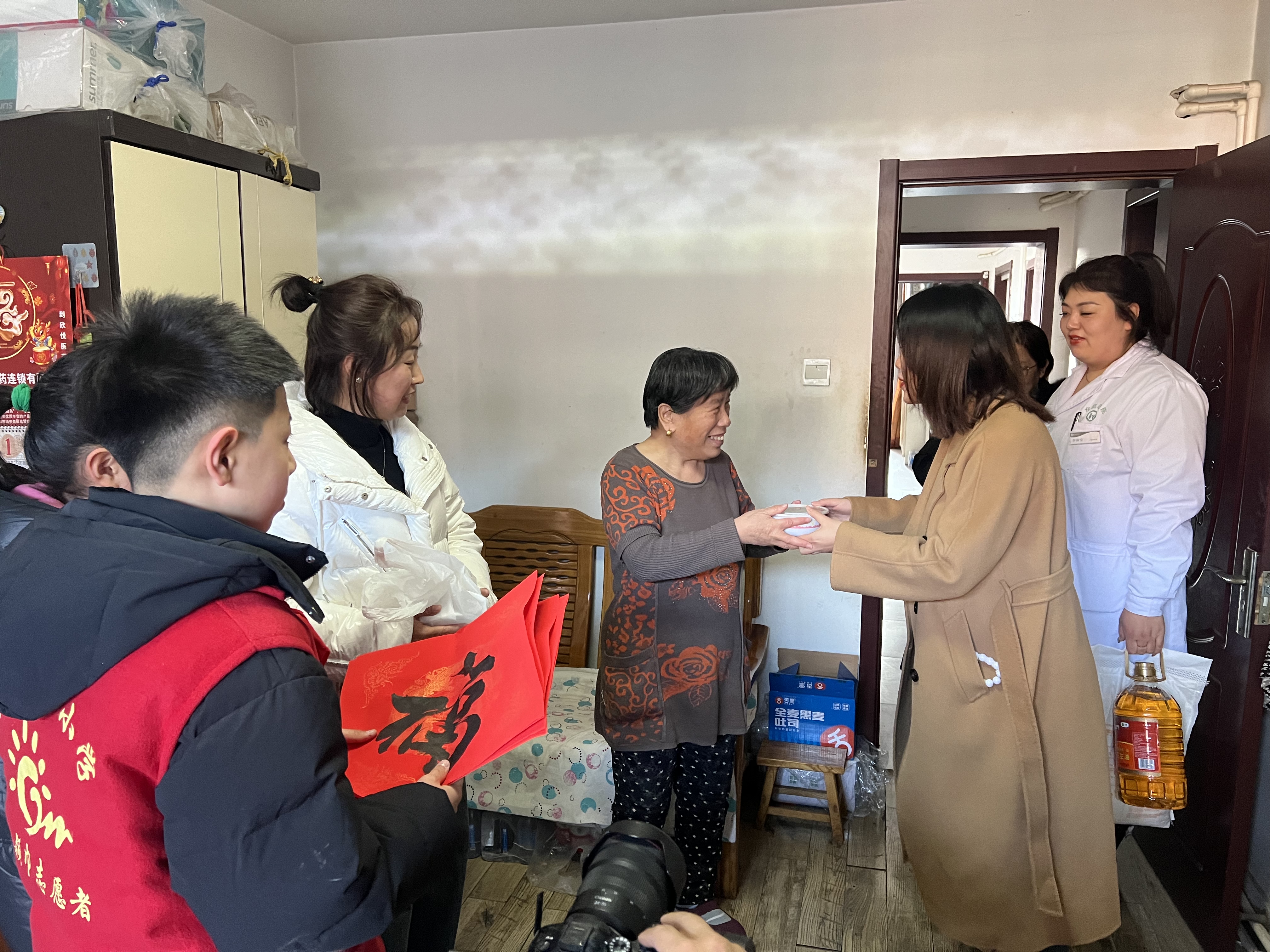 图片默认标题_fororder_活动现场,工作人员和“小小志愿者”为老人送去福字和腊八粥。高博 摄
