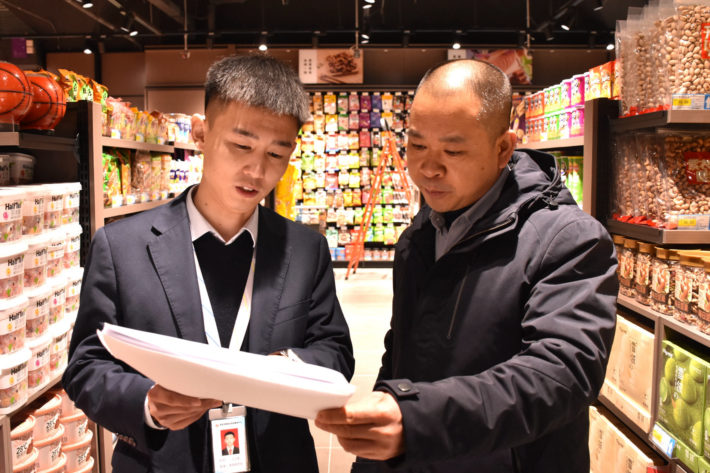 河北清苑:超前辅导为企业解难题_fororder_工作人员为超市经营者讲解食品经营许可证的办理流程。 赵琪摄.JPG