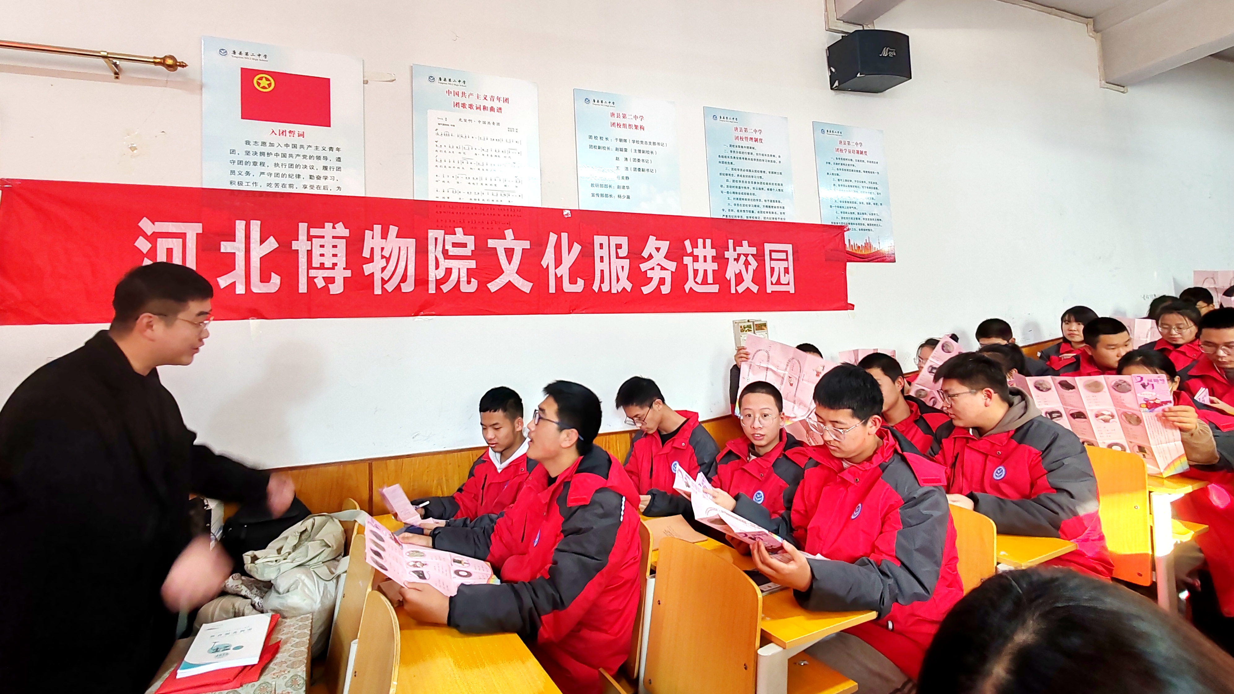 河北唐县:讲述精品文物 传播中华文化_fororder_河北省博物院工作人员为学生发放文物学习手册(马秀涛摄)