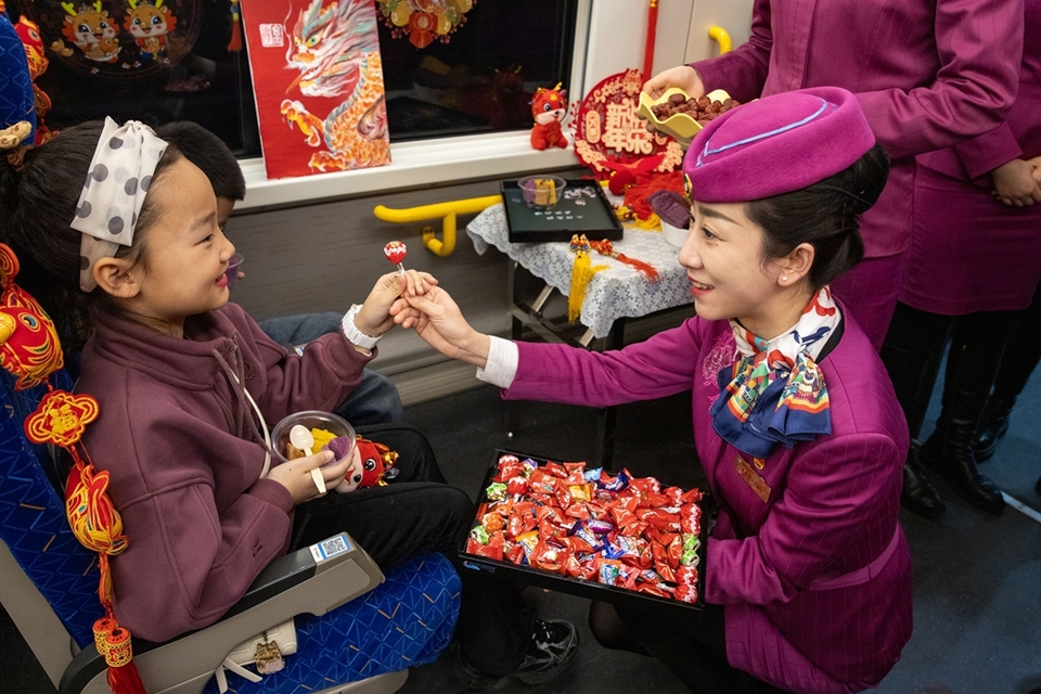 D6165次列车：复兴号上的小年_fororder_2、乘务员给小旅客送上糖果和年糕。章汝慧 摄