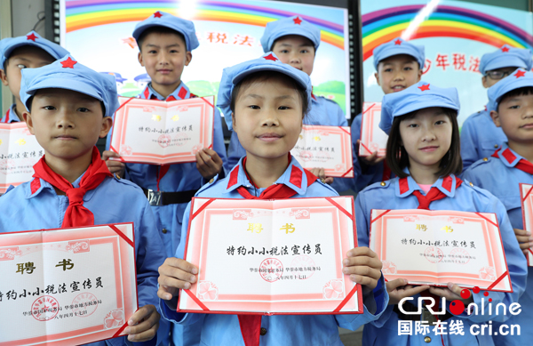 图片默认标题_fororder_特约小小税法宣传员在展示他们领取的聘书