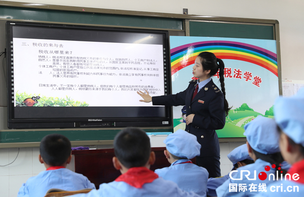 图片默认标题_fororder_税法宣传辅导员在该市青少年税法宣传教育基地红军小学，给“小红军”