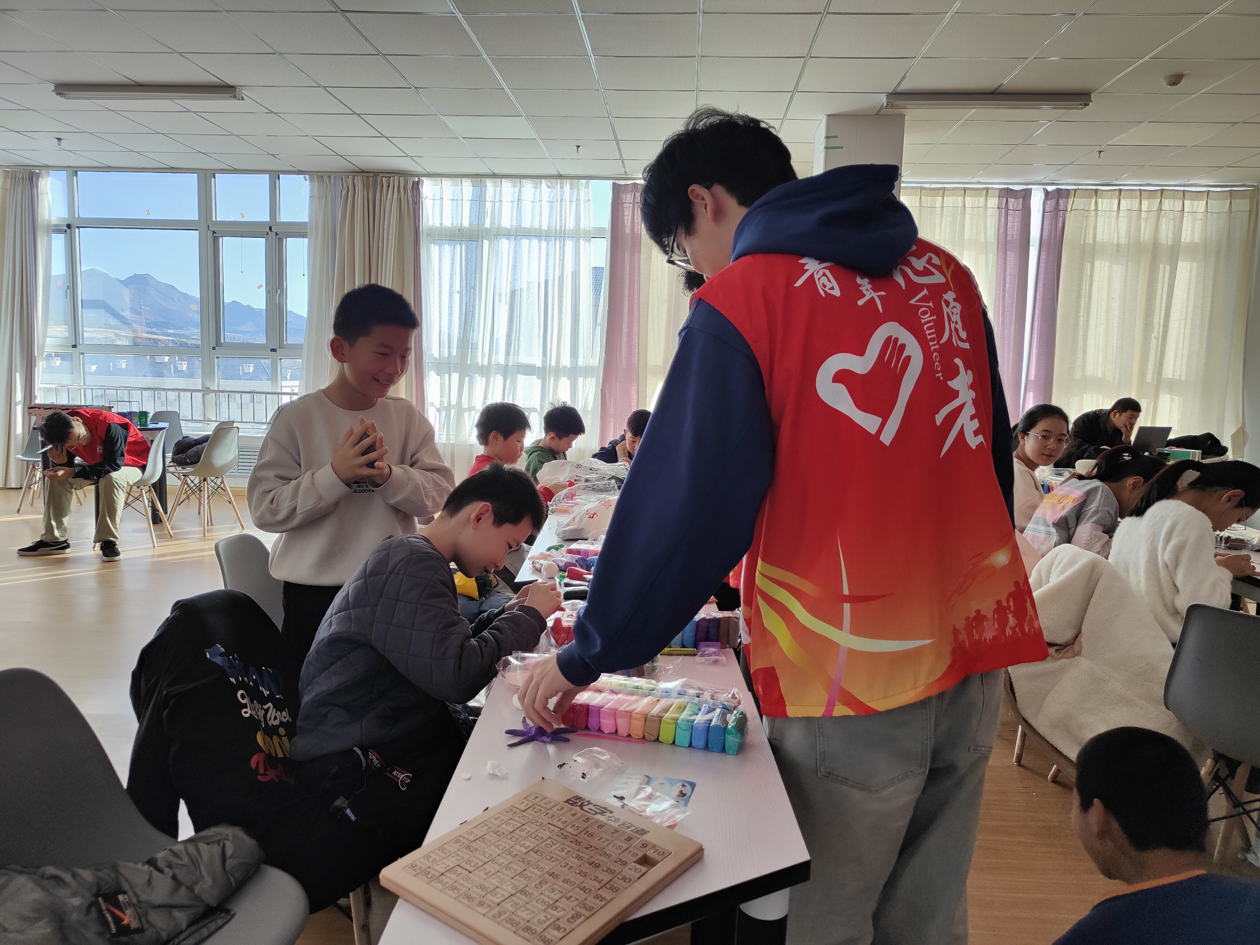 丰宁开展“青‘宁’花开——假期公益课堂文明实践‘助学支教’志愿服务项目手工DIY活动_fororder_志愿者指导孩子们做粘土 拍摄刘余