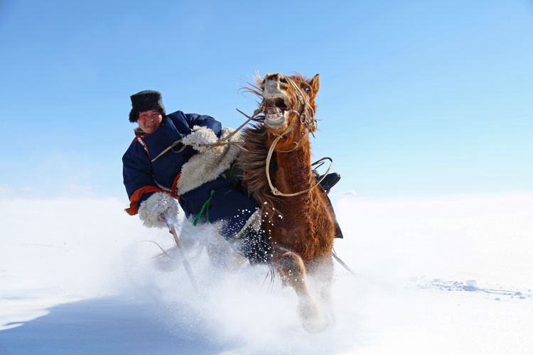 图片默认标题_fororder_牧民在雪地中骑马表演，马背上的特技让人惊叹，这是来自草原的独特魅力。（摄影：索米亚 ）