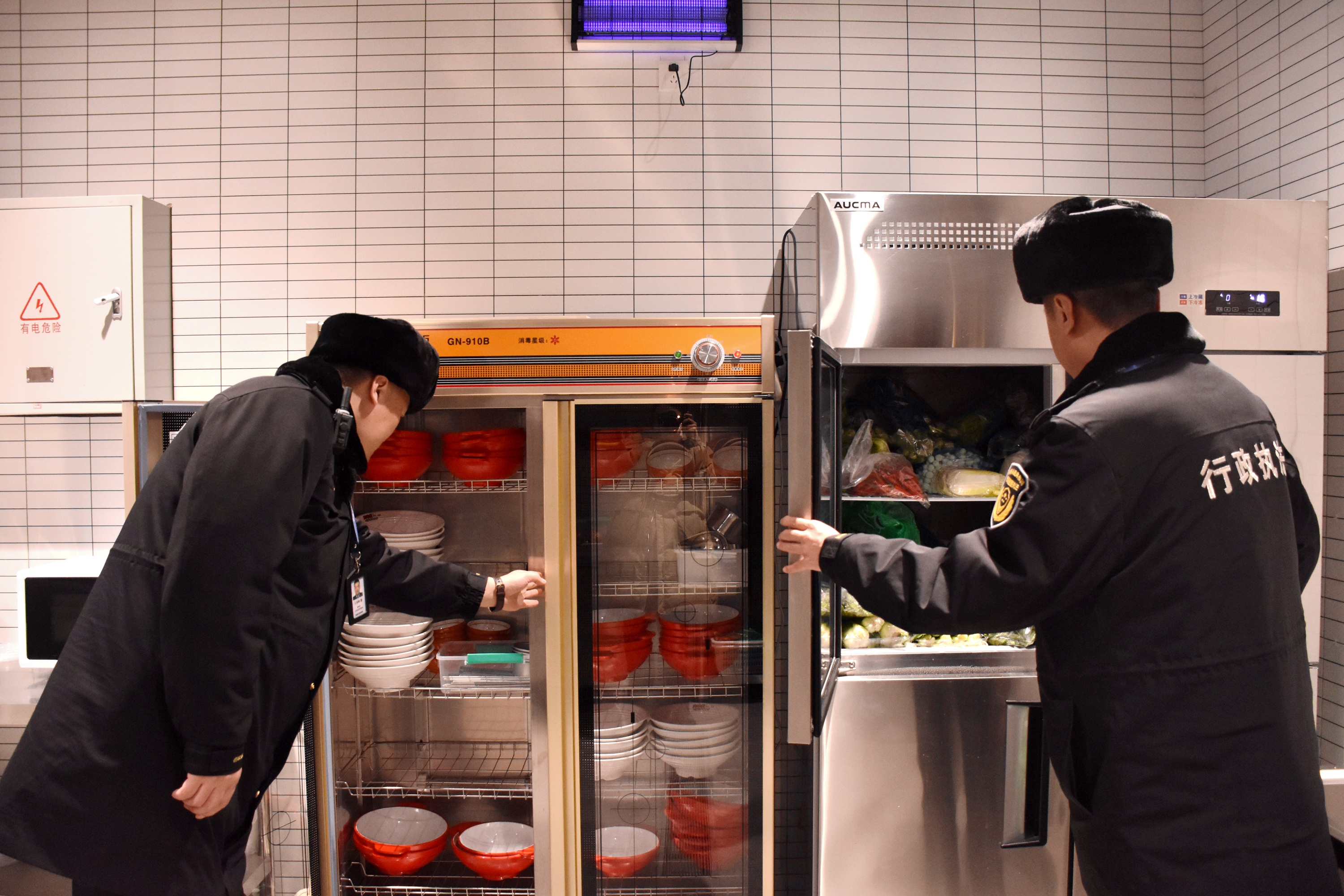 河北清苑:严把食品安全关 保障“舌尖上的安全”_fororder_执法人员查看餐饮店存储条件。 赵琪摄.JPG