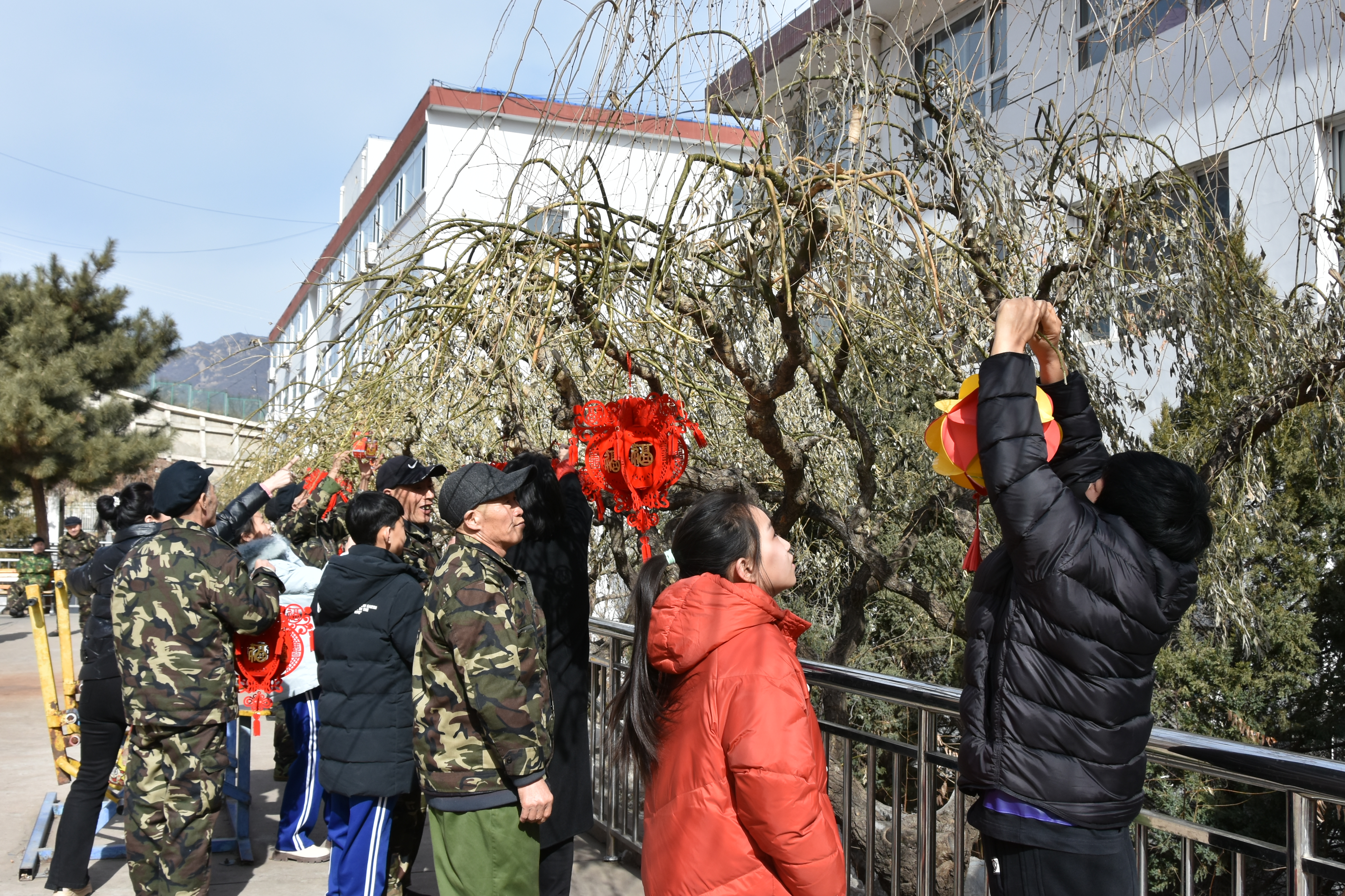 河北承德县:浓情元宵节 情暖老人心_fororder_图一为:家长带领同学们和老人们一起挂灯笼送祝福。井心雨 摄.JPG