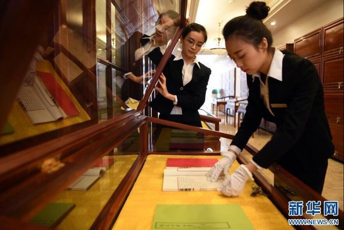 在甘肃天庆博物馆,博物馆工作人员刘妤(右)整理展柜中的影印本文渊阁