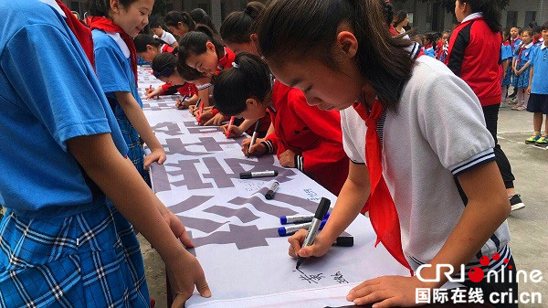 图片默认标题_fororder_学生开展签名活动（乐山市公安局-供图）