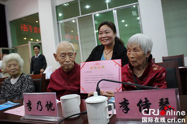 图片默认标题_fororder_江安县委常委、宣传部部长蒋龙珍为李乃忱夫妇颁发证书--摄影张勇