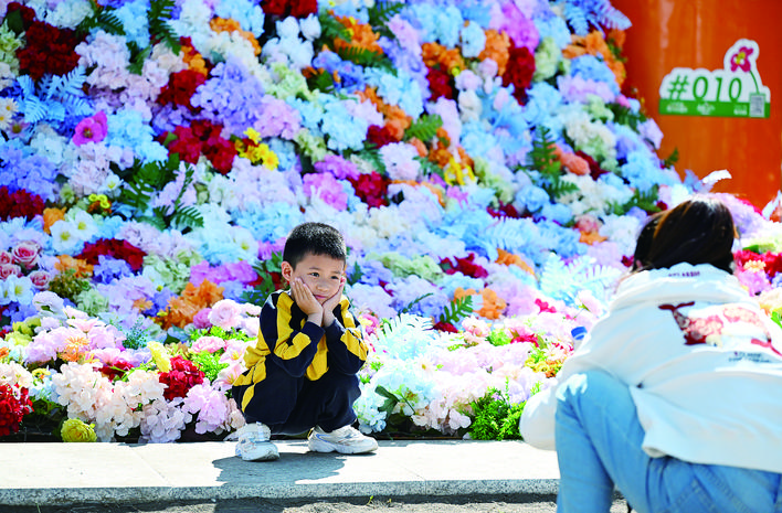 长春：小朋友在花朵瀑布前拍照