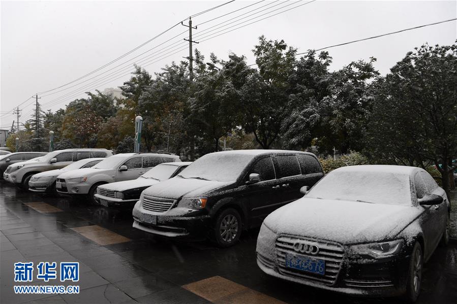 10月27日,在兰州市榆中县,露天停放的车辆被降雪遮盖.