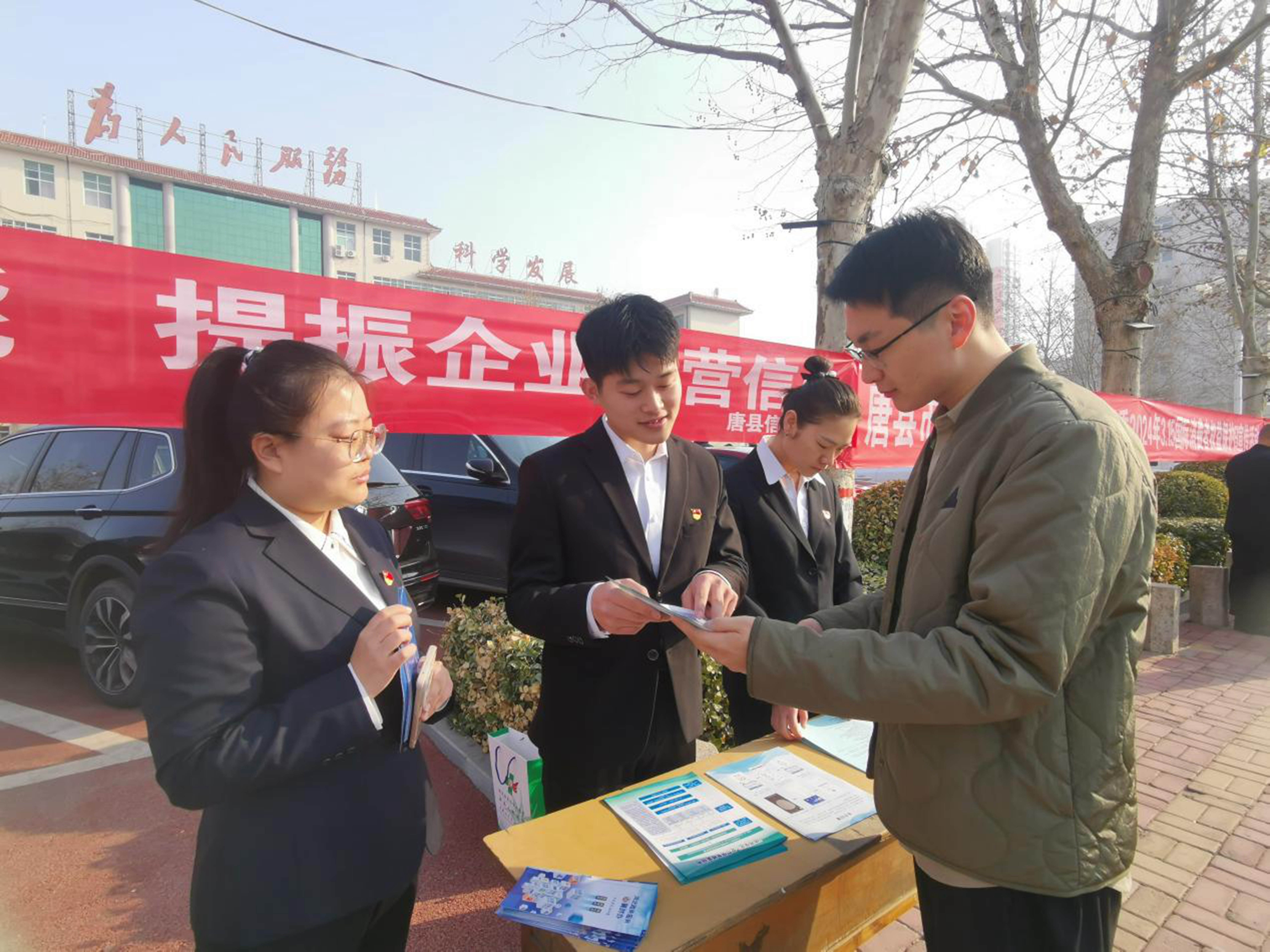 河北唐县:加快社会信用体系建设 打造信用高地_fororder_诚信宣传活动现场,工作人员向群众讲解宣传册