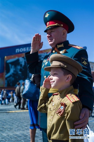 5月9日，在俄罗斯莫斯科，一名老兵与自己的孙子在阅兵结束后合影。5月9日是俄罗斯卫国战争胜利纪念日。俄军方当日在莫斯科举行盛大阅兵式。 新华社记者吴壮摄