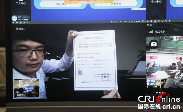图片默认标题_fororder_四川蓝天柱建筑工程有限公司员工向媒体展示通过远程智能办证系统在办公室里打印出证书-左仁义-摄影