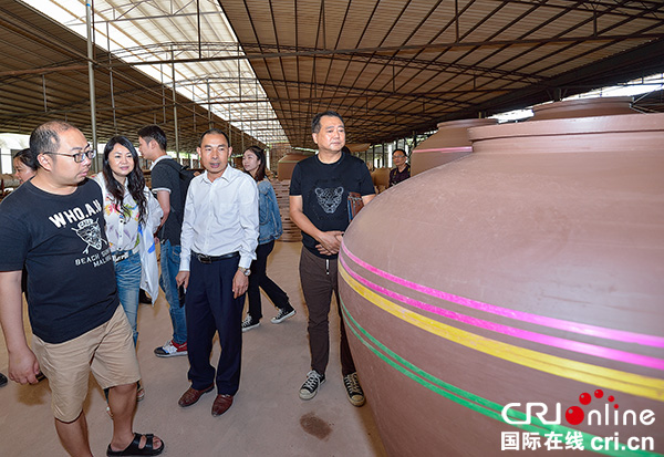 图片默认标题_fororder_刘世阳（右二）向媒体记者介绍工厂生产情况（摄影-廖志全）