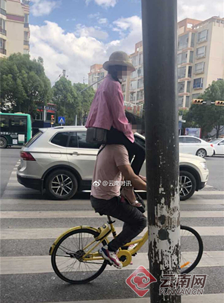 女子坐男子肩上同骑1辆共享单车 网友:活着不好吗