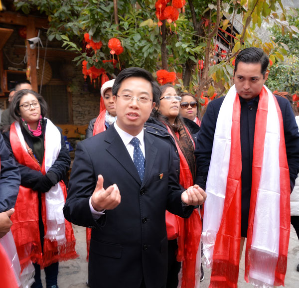 理县县委副书记吴勇刚(右二)向外媒介绍桃坪羌寨文化旅游发展情况