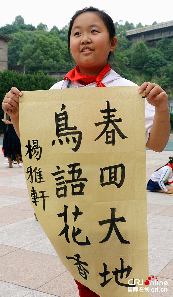 图片默认标题_fororder_少先队员展示自己的书法作品。