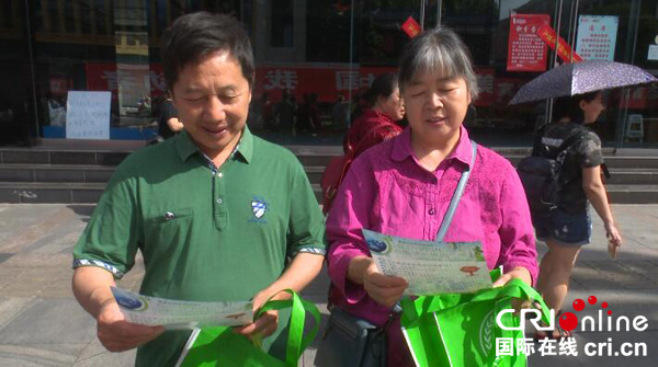 图片默认标题_fororder_市民正在认真阅读宣传资料