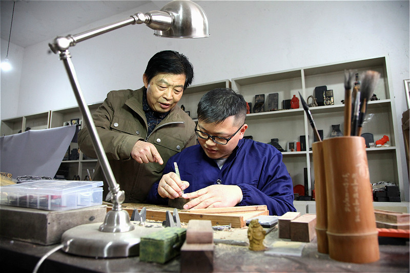 图片默认标题 图片默认标题_fororder_2、黄山市非遗徽墨技艺代表性传承人项颂(右)与父亲项德胜在探讨墨模雕刻技艺。_meitu_2