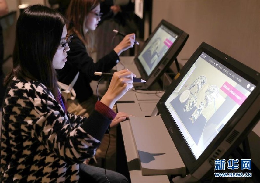 12月19日,工作人员在展览现场演示可供观众操作的青花瓷修复的电脑模拟技术。新华社记者 吴晓初 摄