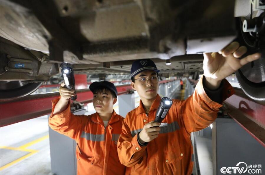 南昌西動車組運用二所檢修庫內(nèi)，機械師在檢修動車組車底部件。