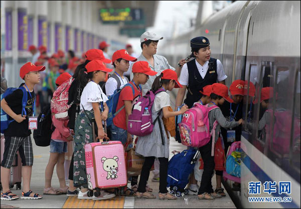 ตำรวจเมืองหย่งจี้ส่งเด็กชนบทขึ้นรถไฟไปพบพ่อแม่ที่ไปทำงานในปักกิ่ง