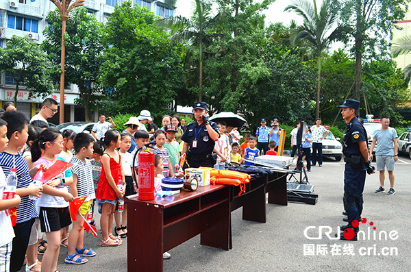 图片默认标题_fororder_巡特警队员向孩子们介绍有关防暴及救援器材