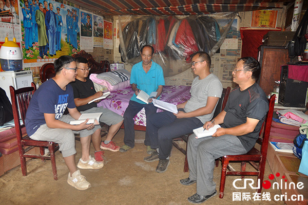 图片默认标题_fororder_驻村工作队员和村干部在住所讨论工作