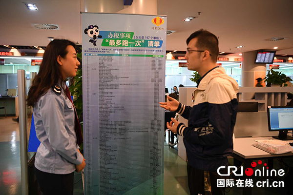 图片默认标题_fororder_成都市高新区税务局工作人员向纳税人介绍“最多跑一次”清单（供图-四川省税务局）