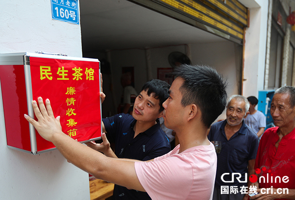 图片默认标题_fororder_工作人员在民生茶馆”悬挂“廉情”收集箱