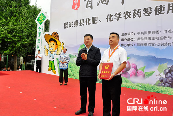 洪雅县委副书记,县长宋良勇(左)向"全国农业劳动模范"付志洪(右)颁发