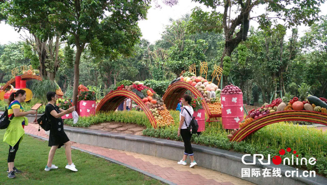 市民游客在园林小品前留影 摄影 冼敏 本次活动由南宁市青秀山管委会、南宁市农业委员会及南宁市青秀区政府共同举办。将开展“百花百果丰收展”、“农耕文化科普展示”、“金秋丰收美食展”、“青秀山兰花组培及压花艺术展示”等丰富多彩的活动,进一步传承弘扬中华农耕文明和传统优秀文化。