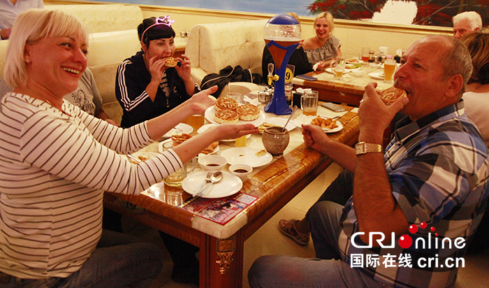 在珲春市一家俄式西餐厅,俄罗斯客人正在品尝