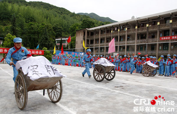 四川华蓥市红岩乡小学的"小红军"在"红色运动会"上参加"推车送军粮"