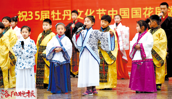 昨日上午,在中国国花园内,百名儿童身着汉服,在牡丹花丛中朗诵