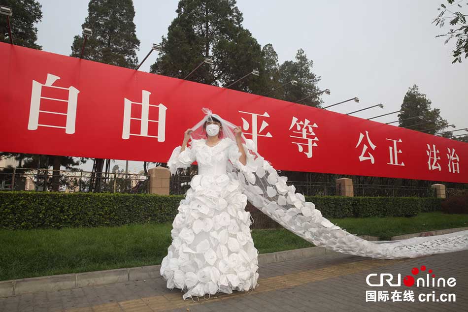 10月20日，北京霧霾持續，雖然今天中午前後開始有冷空氣自東北向京城緩慢滲透，能見度略有好轉，但霾難以消散。藝術家孔寧穿著由口罩製成的婚紗呼籲民眾關注環保、關注生命。攝影：吳皓