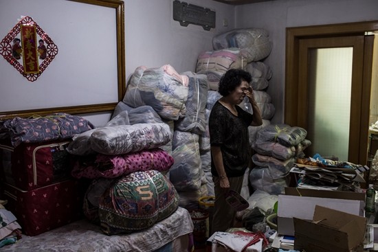 受骗老人吴老太在家中收拾行李,房子被二次过户后,新房主要求她在